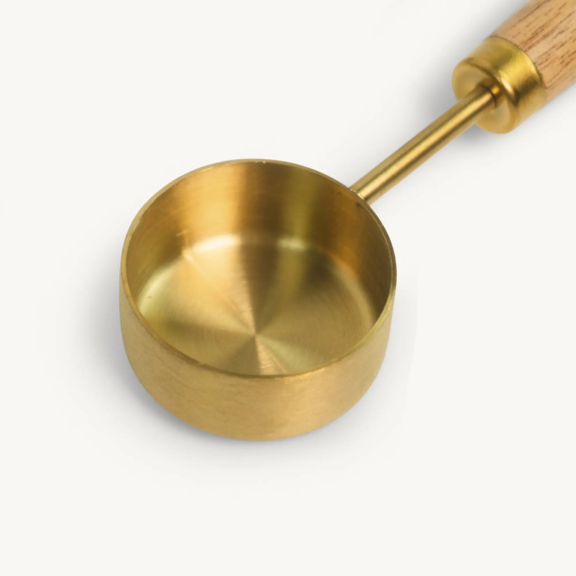 PuriTea scoop close-up — brushed gold stainless steel measuring bowl with acacia wood handle