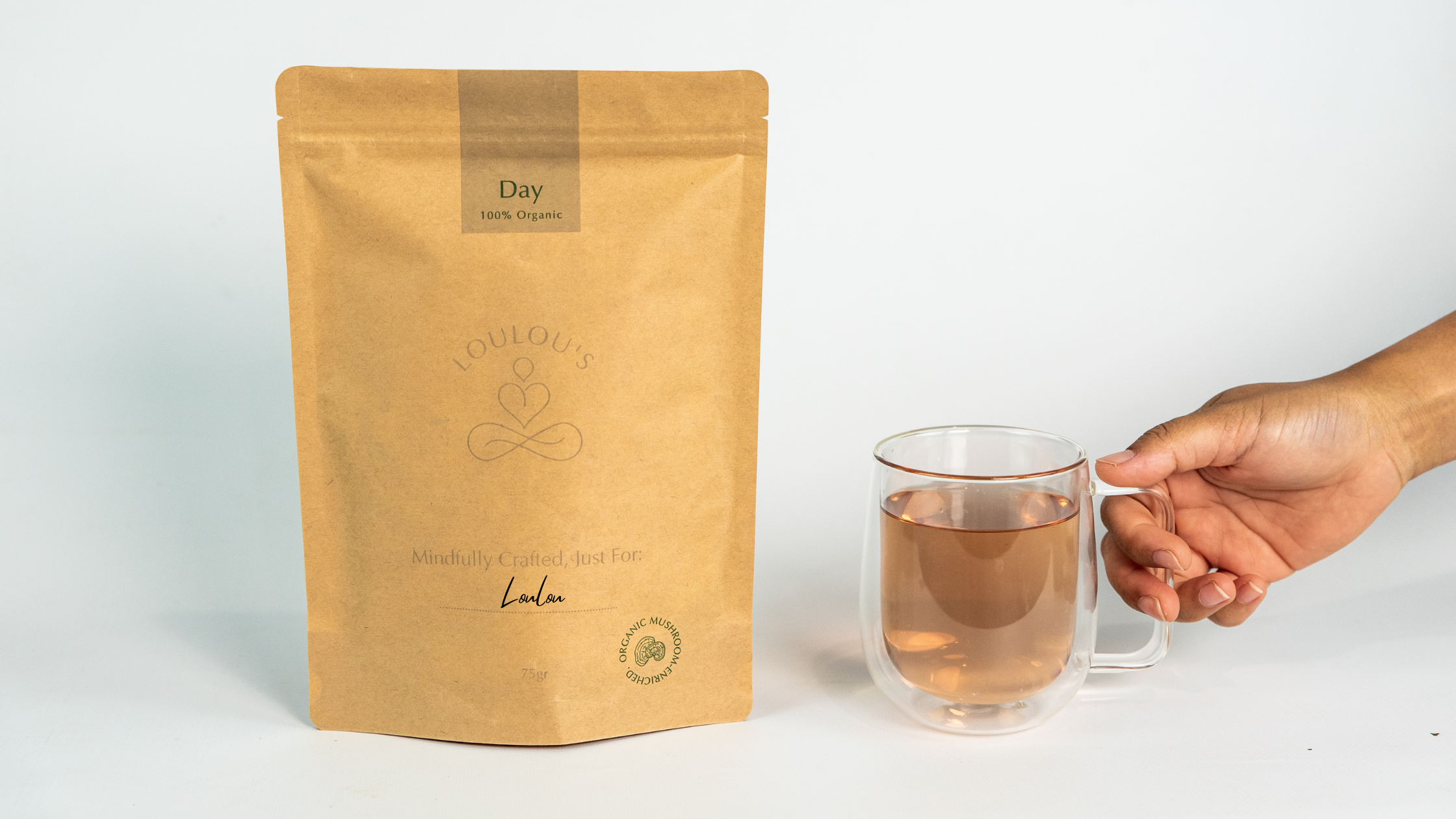 A steaming glass cup of herbal tea on a wooden tray, with warm light and the text ‘Why This Humble Drink Is Your Most Powerful Ritual’ overlaid above.